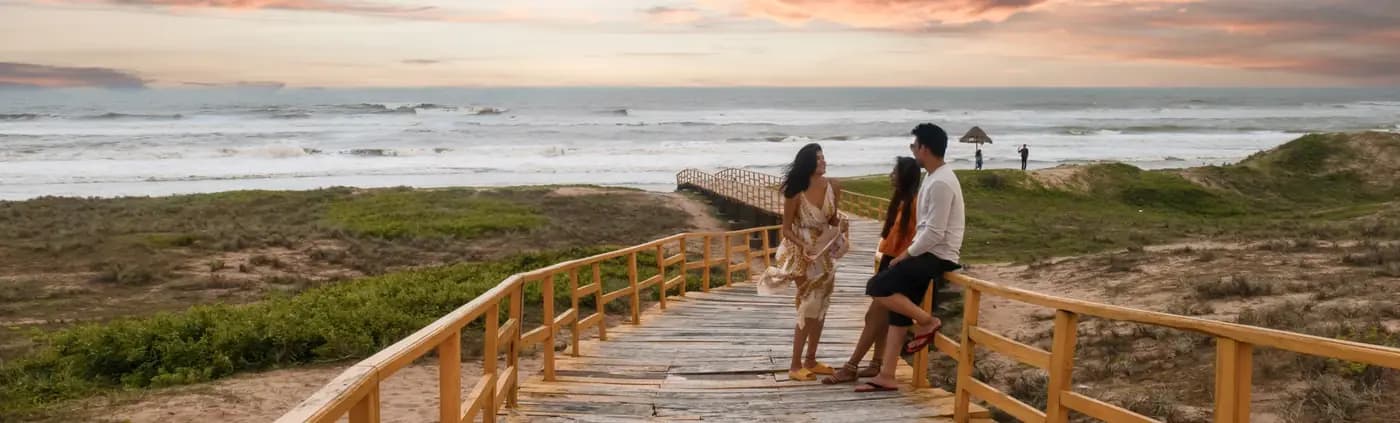 Gopalpur Beach sea and dunes viewed from a wooden beach access boardwalk with visitors