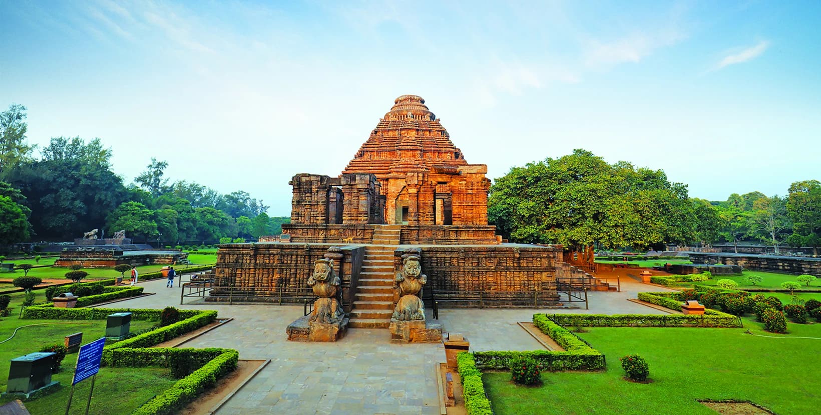 Bright daytime front view of Konark Sun Temple, with its carved stone architecture, entrance sculptures and landscaped grounds