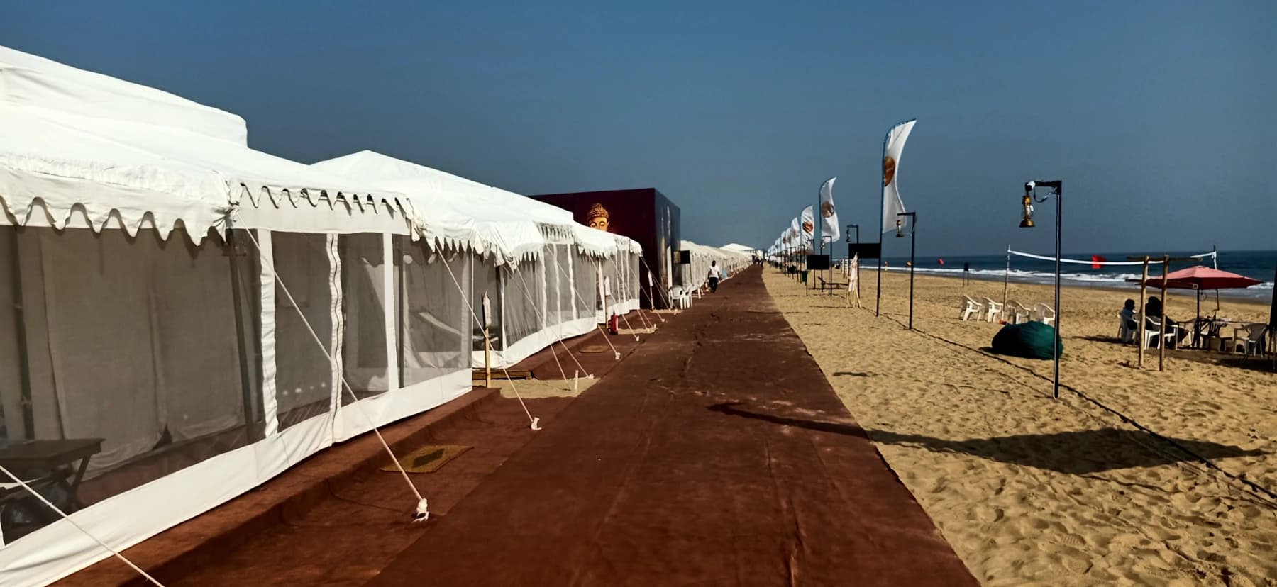 Sunlit Eco Retreat Konark beachfront tents beside Ramachandi Beach, with the sea and surf in view