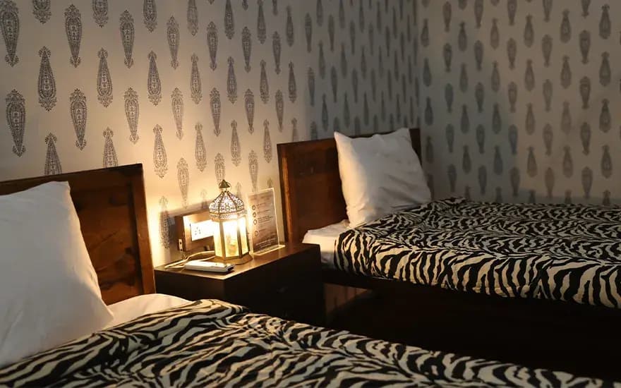 Twin beds with lit bedside table, close view at Rann Utsav — reference